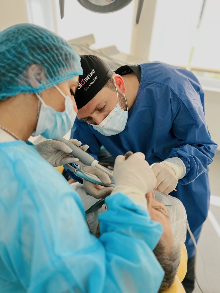 dentiste en train de poser un implant dentaire à un patient en clinique