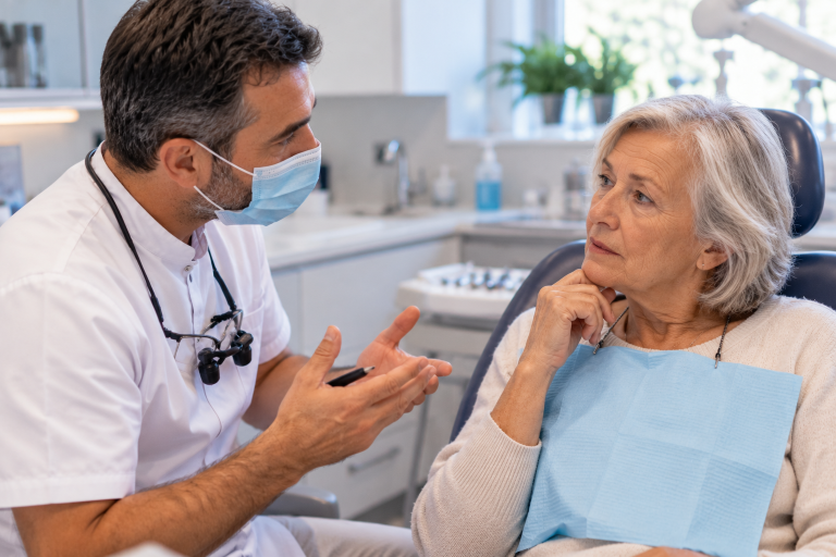 Patiente senior consultant un dentiste avant une greffe osseuse dentaire